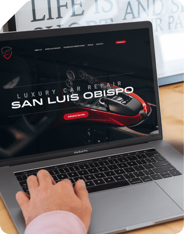Person typing on laptop showing auto repair website